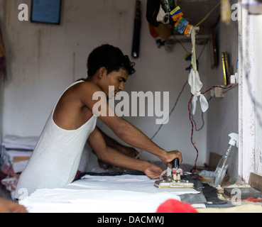 Slum dwellings on Carter Road, Mumbai, small laundry business a Stock Photo