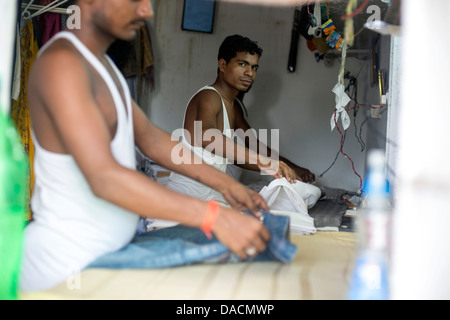 Slum dwellings on Carter Road, Mumbai, small laundry business a Stock Photo