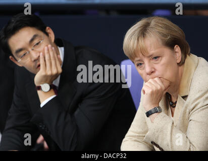 German Chancellor Angela Merkel (R, CDU) sits next to Federal Minister of Economics and Technology Philipp Rösler (FDP) in the Bundestag, Berlin, Germany, 29 September 2011. The Bundestag will have a roll-call vote on the Euro rescue package today. Photo: MICHAEL KAPPELER Stock Photo