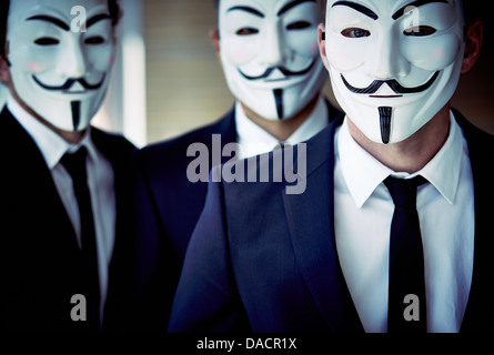 Close-up portrait of unrecognizable people wearing Guy Fawkes masks and business suits Stock Photo