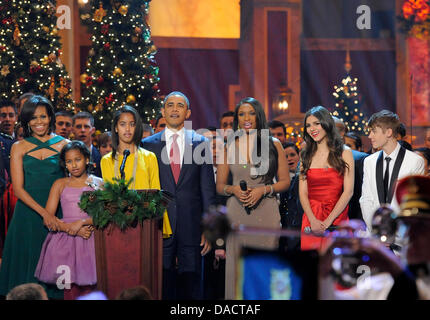 United States President Barack Obama (C), first lady Michelle Obama and daughters Malia and Sasha are joined by entertainers (L-R) Jennifer Hudson, Victoria Justice and Justin Bieber for a final song at the conclusion of the performances at the annual 'Christmas in Washington' gala, December 11, 2011, Washington, DC.  Credit: Mike Theiler / Pool via CNP Stock Photo