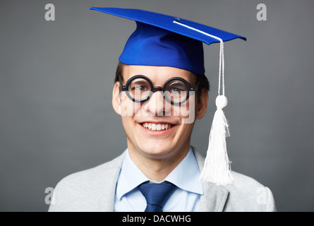 Portrait of a successful graduate in a graduation cap smiling at the viewer Stock Photo