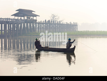 Fisherman on Taungthaman Lake at dawn with U Bein Bridge, Amarapura, near Mandalay, Myanmar Stock Photo