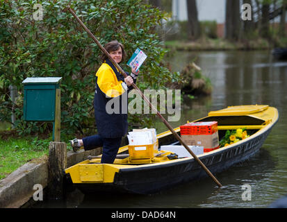 (FILE) An archive photo dated 08 April 2011 shows Germany's only cane boat postwoman, Jutta Pudent, delivering post in the Spreewald in Lehde, Germany. The 59 year old is on her goodbye tour after delivering letters and packages by boat to clients in the Lehde area of Luebbenau for 21 years on Friday, 07 October 2011. Photo: Patrick Pleul Stock Photo