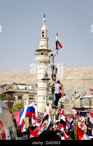 Thousands of Syrians wave national flags along with Chinese and Russian flags during a pro-government rally on Saba Bahrat Square in Damascus, Syria, on 12 October 2011. According to media sources, thousands of Syrians rallied to support the regime of Syrian President Bashar al-Assad, and express appreciation to Russia and China for their supportive stance for Syria. On 04 October, Stock Photo
