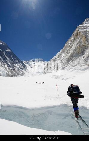 Climbers crossing crevasse and ladder on Mount Everest, Solu Khumbu Everest Region, Sagarmatha National Park, UNESCO Site, Nepal Stock Photo