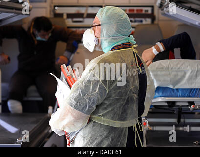 Two of five Libyan fighters lie on stretchers as the paramedic (front, C) supervises the action, on their way to the German Bundeswehr hospital in Westerwede, Germany, 19 September 2011. Altogether 39 injured fighters from the civial war in Libya have already arrived in Hamburg to receive medical treatment in various hospitals in Germany. The men have sustained gunshot wounds and s Stock Photo