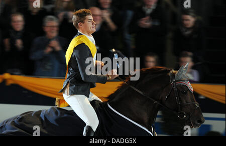 The German equestrian Joerg Oppermann cheers about his victory on his horse Che Guevara during the German Classics in Hanover, Germany, 23 October 2011. Photo: Jochen Luebke Stock Photo