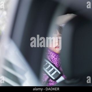 Girl sleeping in back of car Stock Photo