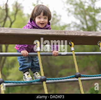 Young girl on climbing frame in playground, portrait Stock Photo