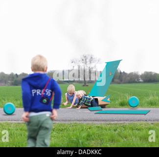 Children playing together in broken airplane model Stock Photo