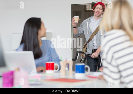 Young man arriving at meeting in creative office Stock Photo