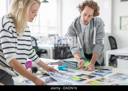 Young colleagues discussing photographs in meeting in creative office Stock Photo