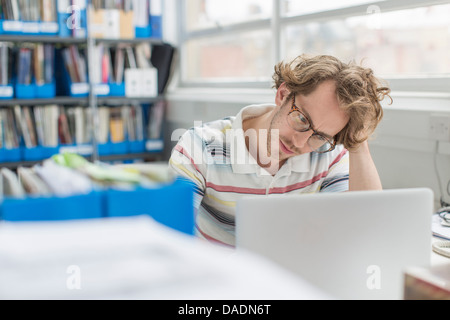 Young man with head in hands in creative office Stock Photo