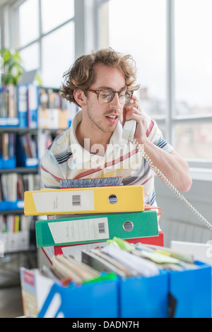 Young man using telephone in creative office Stock Photo