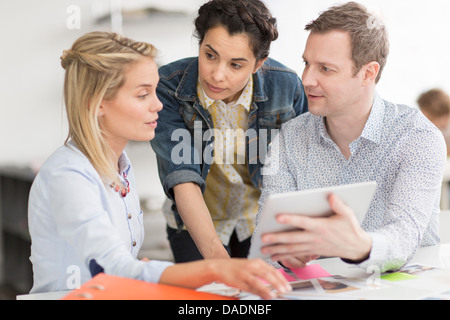 Colleagues discussing plans on laptop at desk Stock Photo