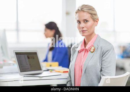 Young businesswoman at desk in office, portrait Stock Photo