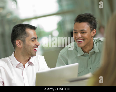 Young student looking at laptop with mid adult tutor, smiling Stock Photo