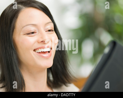 Mature woman using digital tablet and smiling Stock Photo