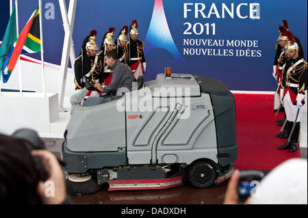 A man tries to remove large puddles of rain water with a special hoover at the G20 summit in Cannes, France, 04 November 2011. On 03 and 04 November 2011, the heads of state of the leading world economies (G20) meet for this year's summit. Photo: PEER GRIMM Stock Photo