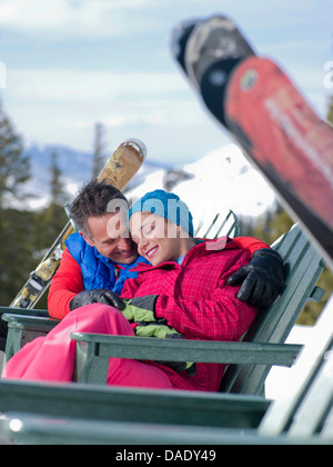 Mature man and young woman relaxing together in ski resort Stock Photo