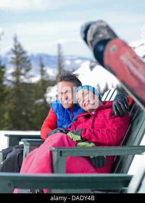 Mature man and young woman relaxing together in ski resort Stock Photo