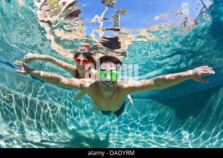YYoung couple swimming underwater in pool Stock Photo
