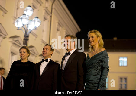 German President Christian Wulff (2nd R), his wife Bettina (R) and Russian President Dmitry Medvedev and his wife Svetlana Vladimirovna Medvedeva poses for photographers as they arrive for an official state dinner at Bellevue palace in Berlin on November 8, 2011. Medvedev inaugurated the Nord Stream pipeline pumping Russian gas to Western Europe in the northern German city of Lubmi Stock Photo