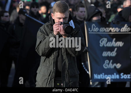 A participant of a neo-Nazi demonstration wearing the sign 'press' on his jacket takes pictures of journalists in Wunsiedel, Germany, 13 November 2011. More than 350 people attended an inauguration of a memorial site in Wunsiedel and remembered the victims of the death marches from CC Buchenwald to the Concentration Camp in Flossenbuerg. At the same time, around 250 neo-Nazis took  Stock Photo