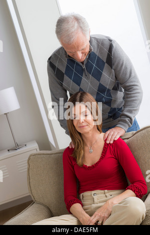 Senior man massaging woman's shoulders Stock Photo