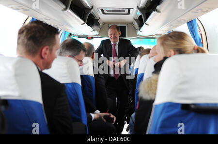 Hamburg's first mayor Olaf Scholz (M) stands inside a bus while going to the China-EU School of Law in Bejing, China, 15 November 2011. Scholz visits China and Japan during his first official trip abroad as head of government. Photo: ANGELIKA WARMUTH Stock Photo