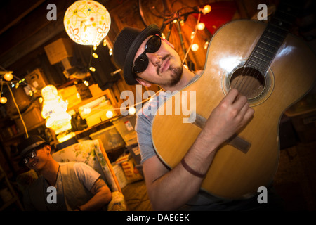Man wearing hat and sunglasses playing guitar Stock Photo
