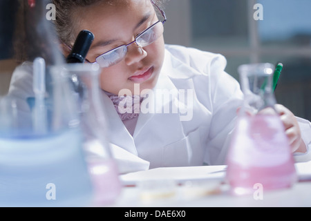 Girl making notes in laboratory Stock Photo
