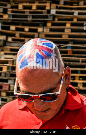 Newtownabbey, Northern Ireland. 11th July 2013. A man wears a Ulster Volunteer Force polo shirt, union flag sunglasses, and has Union Flag painted on his head at a loyalist bonfire. Credit:  Stephen Barnes/Alamy Live News Stock Photo
