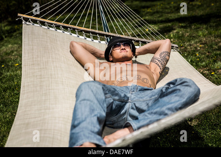 Man lying in hammock Stock Photo