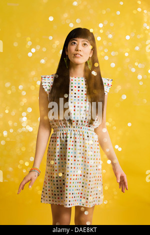 Portrait of young woman wearing spotted dress with glitter Stock Photo