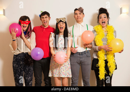 Friends at a party with balloons, studio shot Stock Photo