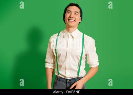 Portrait of young man wearing green braces Stock Photo