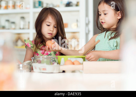 Two young sisters learning how to bake Stock Photo