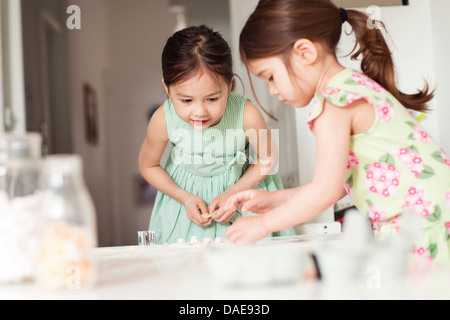 Two young sisters making pastry Stock Photo