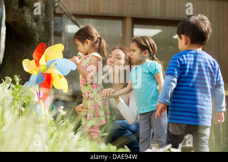Mother and three children with toy windmill in garden Stock Photo