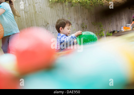 Male toddler playing in garden with balloon Stock Photo
