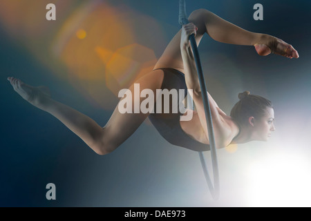 Side view of aerialist performing on hoop Stock Photo