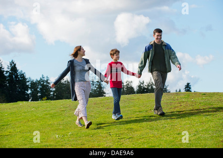 Parents and son walking hand in hand Stock Photo