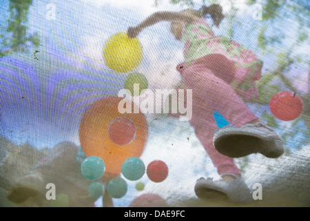 Young girls bouncing on garden trampoline Stock Photo