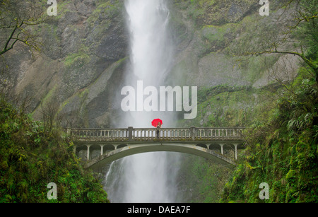 Woman with red umbrella in front of Multnomah Falls, Columbia River Gorge, USA Stock Photo