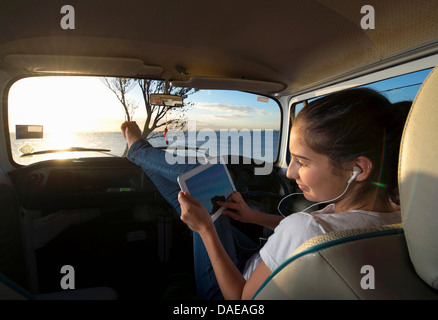 Young woman in camper van using digital tablet Stock Photo