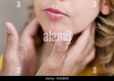 Doctor examining mid adult woman's throat, close up
