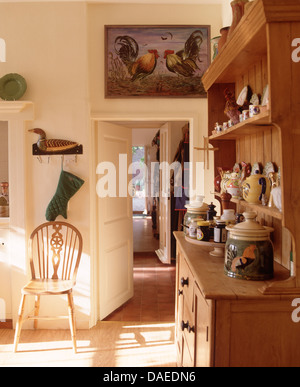 Display Of Pottery On Small Pine Dresser In Country Dining Room With Windsor Chair Beside Open Display Of Pottery On Small Pine Dresser In Country Dining Room With Windsor Chair Beside Open