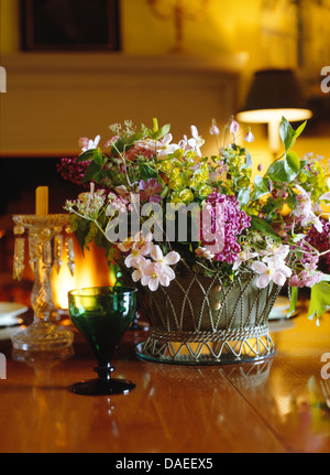 Arrangement of spring flowers on antique table in country dining room Stock Photo